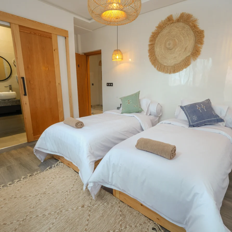 Twin beds in Tafoukt Room with Moroccan lamps and pillows