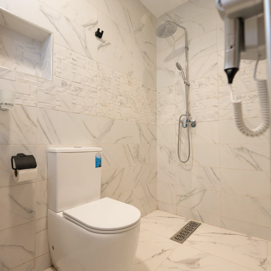 Private bathroom with marble tiles and walk-in rain shower in the Double Room with Mountain View