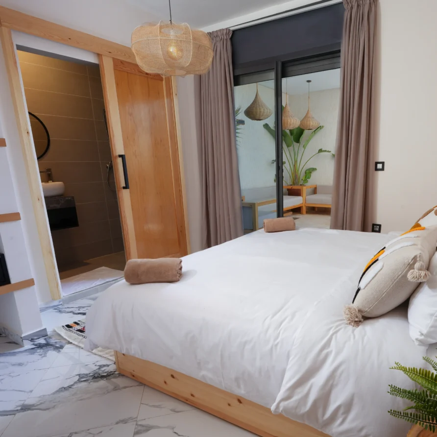 Entire Deluxe Double Room with bed, dressing area and garden outlook at Residence Imsouane Surf Camp.